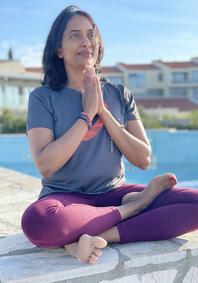 Praji in namaste pose by the pool